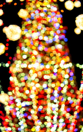 Large New Years Christmas tree decorated with luminous multi-colored garlands and illumination at night. Christmas tree with flashing lights. Blurred background. New Year and Christmas holidaysの写真素材