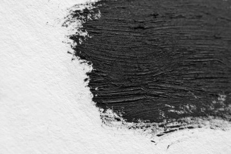 Brush strokes of black acrylic paint close-up. Edge of Smeared Acrylic Black Spot isolated on white background. Abstract creative background. Art drawing texture concept. Copy space, space for textの写真素材