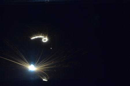 Metal 3D printer printing three-dimensional object from metal powder in dark close-up. Selective...