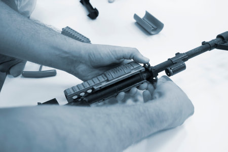 3D printed weapon parts. Man assembles weapon rifle, some parts printed on 3D printer. Details of gray color of weapon printed on 3D printer from polyamide powder. Progressive additive technologyの写真素材