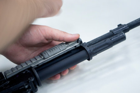 3D printed weapon parts. Man assembles weapon rifle, some parts printed on 3D printer. Details of gray color of weapon printed on 3D printer from polyamide powder. Progressive additive technologyの写真素材