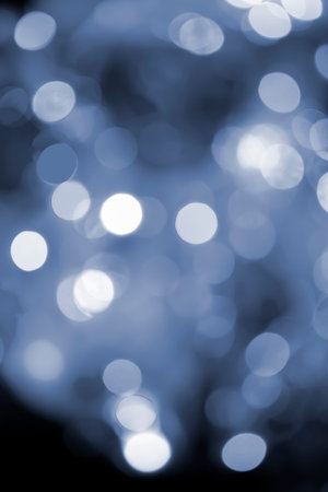 Festive flashing abstract background. Blurred texture background with round bokeh spots. Multicolored blinks background. Celebration New Year Christmas Birthday Flickering illumination Blue colorの写真素材