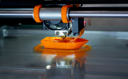 3d printer printing a model close-up. The process of printing a model on a 3D printer made of orange...