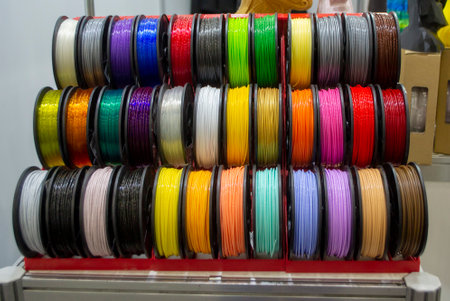 Many multi-colored spools of thread of filament for printing 3d printer. Material coils for printing 3D printer. Spools of 3D printing motley different colors filament. ABS wire plastic for 3d printerの写真素材