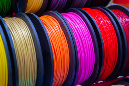 Many multi-colored spools of thread of filament for printing 3d printer. Material coils for printing 3D printer. Spools of 3D printing motley different colors filament. ABS wire plastic for 3d printerの写真素材