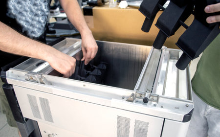 Man takes out model printed 3D printer from the workspace of a big industrial 3D printer. Model printed from polyamide powder. Two workers print an object on a powder 3D printer. Multi Jet Fusionの写真素材