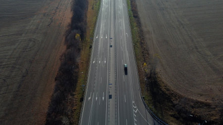 Cars driving along the highway on an autumn sunny day. Automobile road with white markings between...