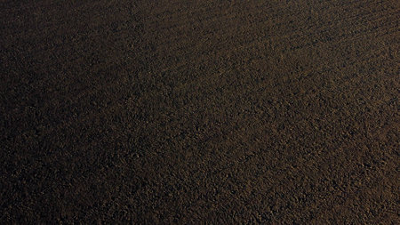 Landscape of plowed up land on an agricultural field on a sunny autumn day. Flying over the plowed earth with black soil. Black soil. Ground earth dirt priming aerial drone view. Agrarian backgroundの写真素材