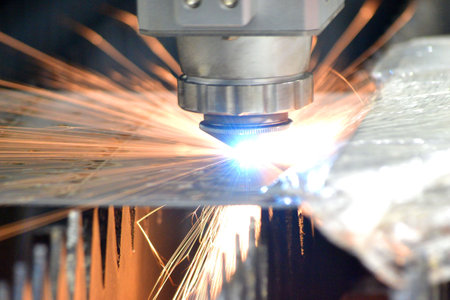 Metal laser cutting. Cutting sheet of metal by laser metal cutting close-up. Industrial equipment machine for cutting metal in factory. Moving head with sparks. Metalwork manufacturing backgroundの写真素材