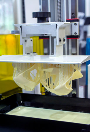 Printed models on 3D printer close-up. Objects printed on photopolymer sla 3D printer from liquid photopolymer resins on printing platform. Modern progressive additive technology. 3D printer printingの写真素材