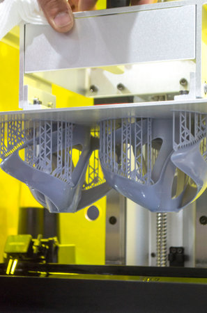 Printed models on 3D printer close-up. Objects printed on photopolymer sla 3D printer from liquid photopolymer resins on printing platform inside 3d printer. Modern progressive additive technology.の写真素材