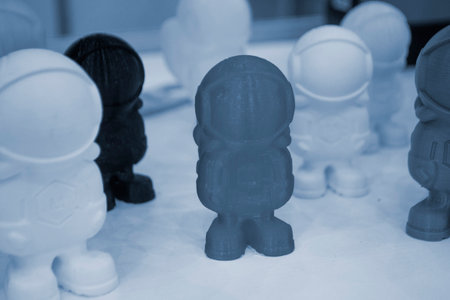 Art object model of astronaut printed on 3D printer. Toy created by 3D printing from molten plastic....
