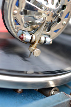 An old retro record playing on old vintage gramophone at flea market. Work of portable gramophone....