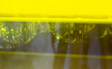 Working of photopolymer sla 3D printer. Platform with building object lowered into liquid...