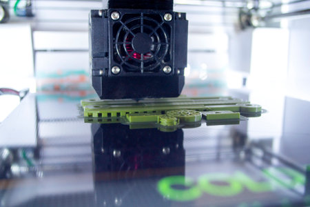 3D printer close up. A working 3D printer in process of printing object from molten plastic. 3D...