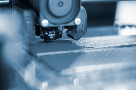 3D printer close up. A working 3D printer in process of printing object from molten plastic. 3D...