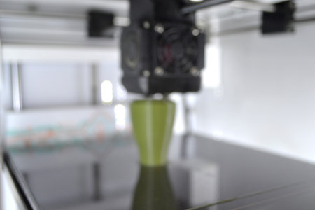 3D printer close up. A working 3D printer in process of printing object from molten plastic. 3D...