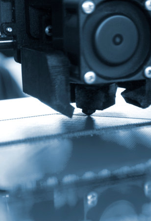 3D printer close up. A working 3D printer in process of printing object from molten plastic. 3D...