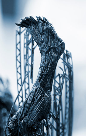 Model of leg printed on a 3D printer from black rubber, close-up. Part of an object created on a 3D...