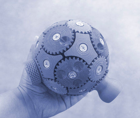 A person holding in his hand an object printed on a 3D printer. Geometric model printed on a 3D printer from molten plastic close-up. Shape created by 3D printer. FDM technology.の写真素材