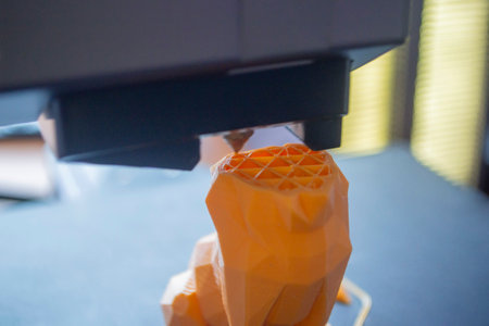 3D printer close-up. The process of working of 3D printer. 3D printer printing object from molten plastic. 3D printer creating model by flowing liquid plastic from an extruder. Printing technologyの写真素材