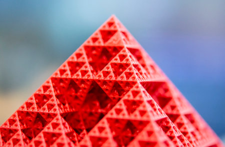 Art object printed on 3D printer from red melted plastic close-up. Model of pyramid created on 3D printer from plastic. 3D Printing technology. Additive progressive technology. New modern technologiesの写真素材