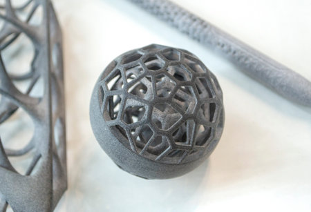 Model printed on 3D printer from grey polyamide powder close-up. Detailed prototype created on 3D...