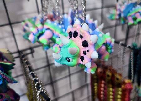 Objects keychains in form of models of toys colorful dinosaur printed on 3D printer from...