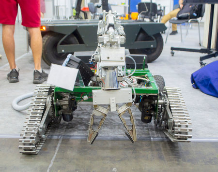 Small robot car unmanned with a crane and on tracks. Robotization robotics, new technology, radio control transport robot. Technological entertainmentの写真素材