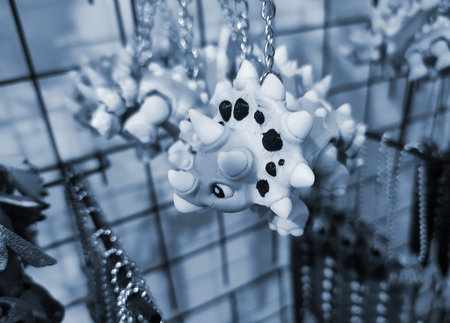 Objects keychains in form of models of toys colorful dinosaur printed on 3D printer from multi-colored molten plastic hanging on chain. Concept 3D Printing. 3D Printing additive technology.の写真素材