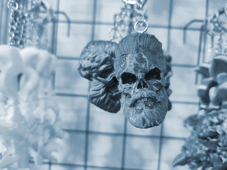 Objects keychains in form of skull of man, models of toys printed on 3D printer from molten plastic hanging on chain. Concept 3D Printing. New modern 3D Printing additive technology. Blue colorの写真素材