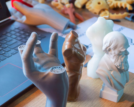Small different figures made of plastic printed on a 3D printer on the table close-up. FDM. Concept...