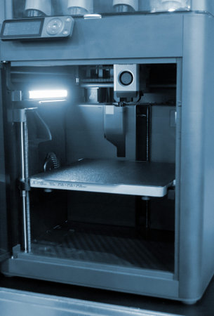3D printer. 3D printer with a blank build surface. Open 3D printer. 3D printer with an empty work...