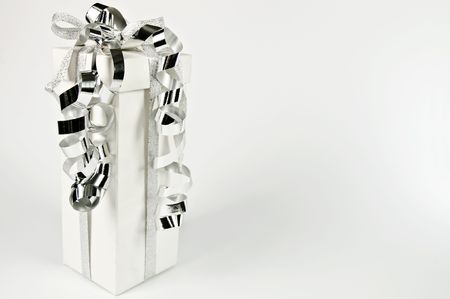 Gift bag with ribbon on a white and silver Christmas tree ball の写真素材