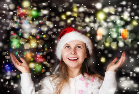 Happy beautiful little girl looks at the sky in the Christmas nightの写真素材
