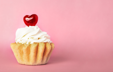 Shortbread cake with sweet decoration in the form of hearts on a pink backgroundの写真素材