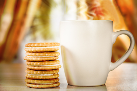 Hot drink and cookies with a stuffing on a background of a window with sunlightの写真素材