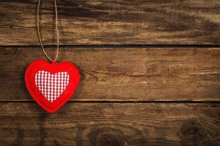 Soft red heart made of cloth hanging on jute threadの写真素材