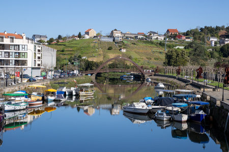 Traditional white buildings seen from a bridge over a river in Spain, surrounded by lush greenery.の写真素材