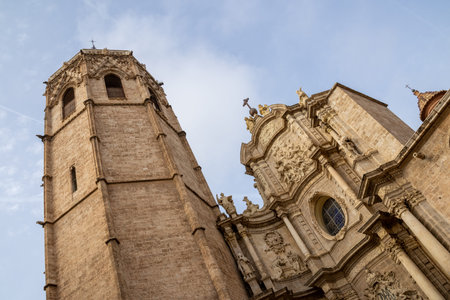 Valencia Cathedral and Miguelete Tower (Micalet) from Plaza de la Reina, Spain. A Gothic masterpiece standing tall, framed by the lively ambiance of one of Valenciaの写真素材