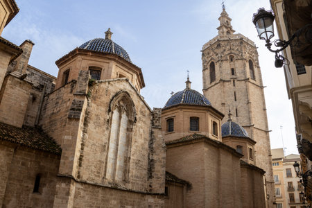 Valencia Cathedral and Miguelete Tower (Micalet) from Plaza de la Reina, Spain. A Gothic masterpiece standing tall, framed by the lively ambiance of one of Valenciaの写真素材