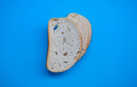 Three slices of white wheat bread on a blue background, front view.の写真素材
