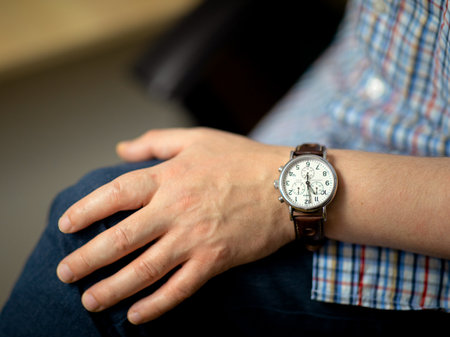Classic men's timex watch with leather strap matched to the left hand with eleven o'clockのeditorial素材