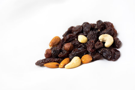 A healthy snack of a mixture of nuts and raisins on a white backgroundの写真素材