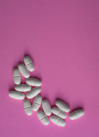 White large pills on a pink backgroundの写真素材