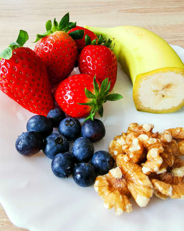 A healthy snack. Nuts, highbush blueberry, strawberries, and banana