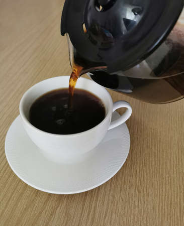 Break on coffee drink. Mug of hot filtered coffee from a glass potの写真素材