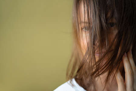 Portrait of a woman with brown hair on her face. Focus on the hairの写真素材