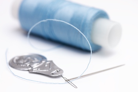 Needle threader, needle  and spool of thread on white backgroundの写真素材