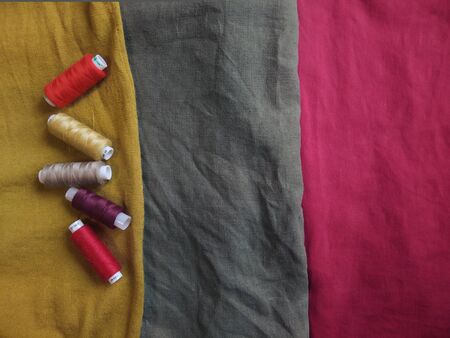 Spools of thread on Textile linen wool cotton background of bright colors